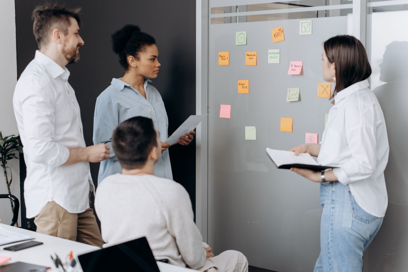 A team working through sticky notes at a whiteboard